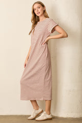woman wearing a light pink and white striped midi dress with short sleeves and side pockets