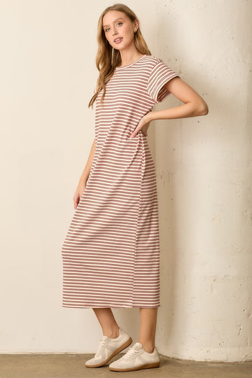 woman wearing a light pink and white striped midi dress with short sleeves and side pockets