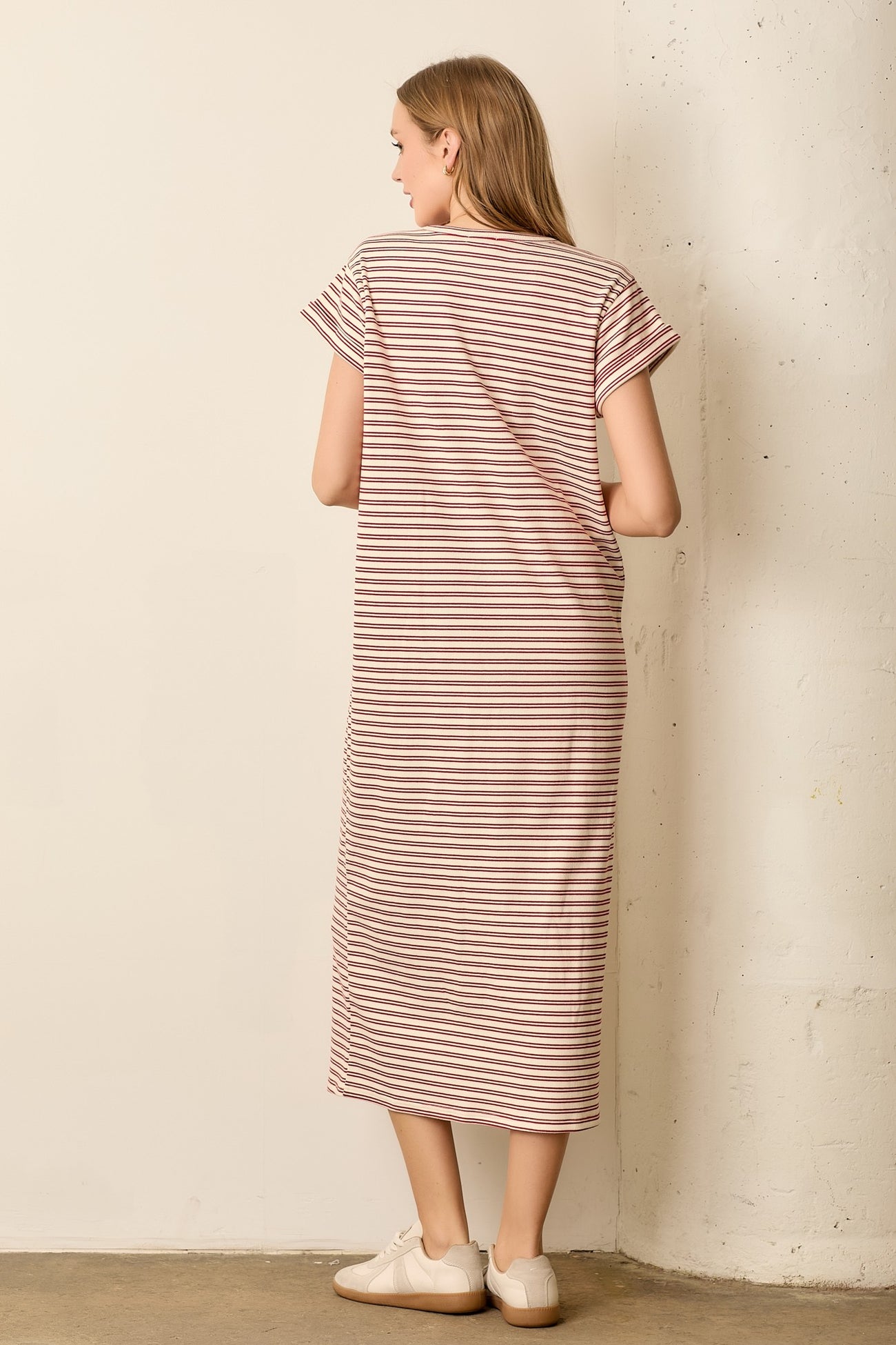 woman wearing a striped pink and white maxi dress with short sleeves and a relaxed fit