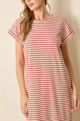 woman wearing a red and cream striped short sleeve t-shirt dress standing against a light background