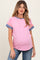 woman wearing a pink ribbed maternity top with blue striped sleeves and a visible baby bump