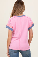 woman wearing a striped pink and blue short sleeve maternity top, viewed from the back
