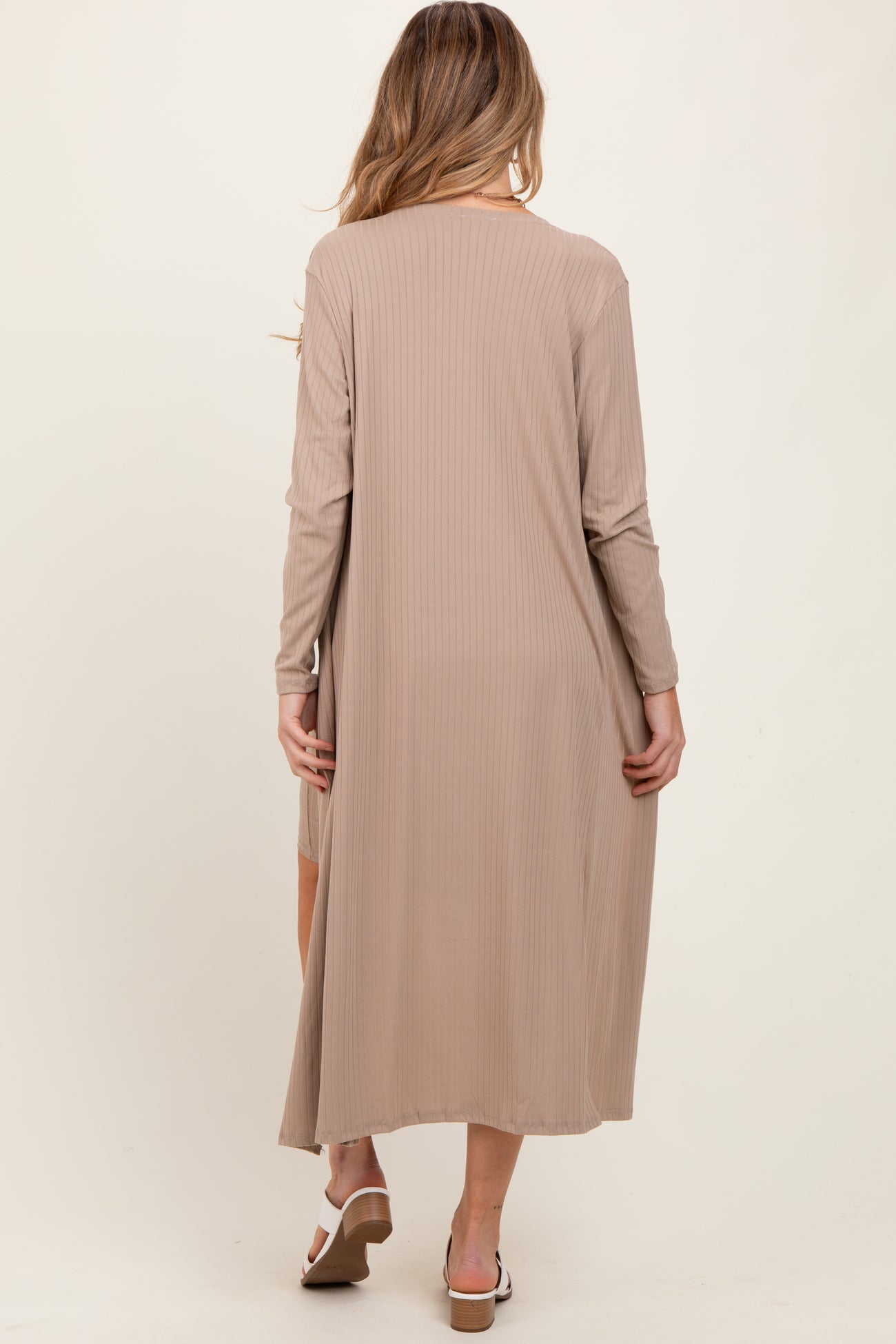woman wearing a long beige ribbed maternity dress with long sleeves, showing the back view