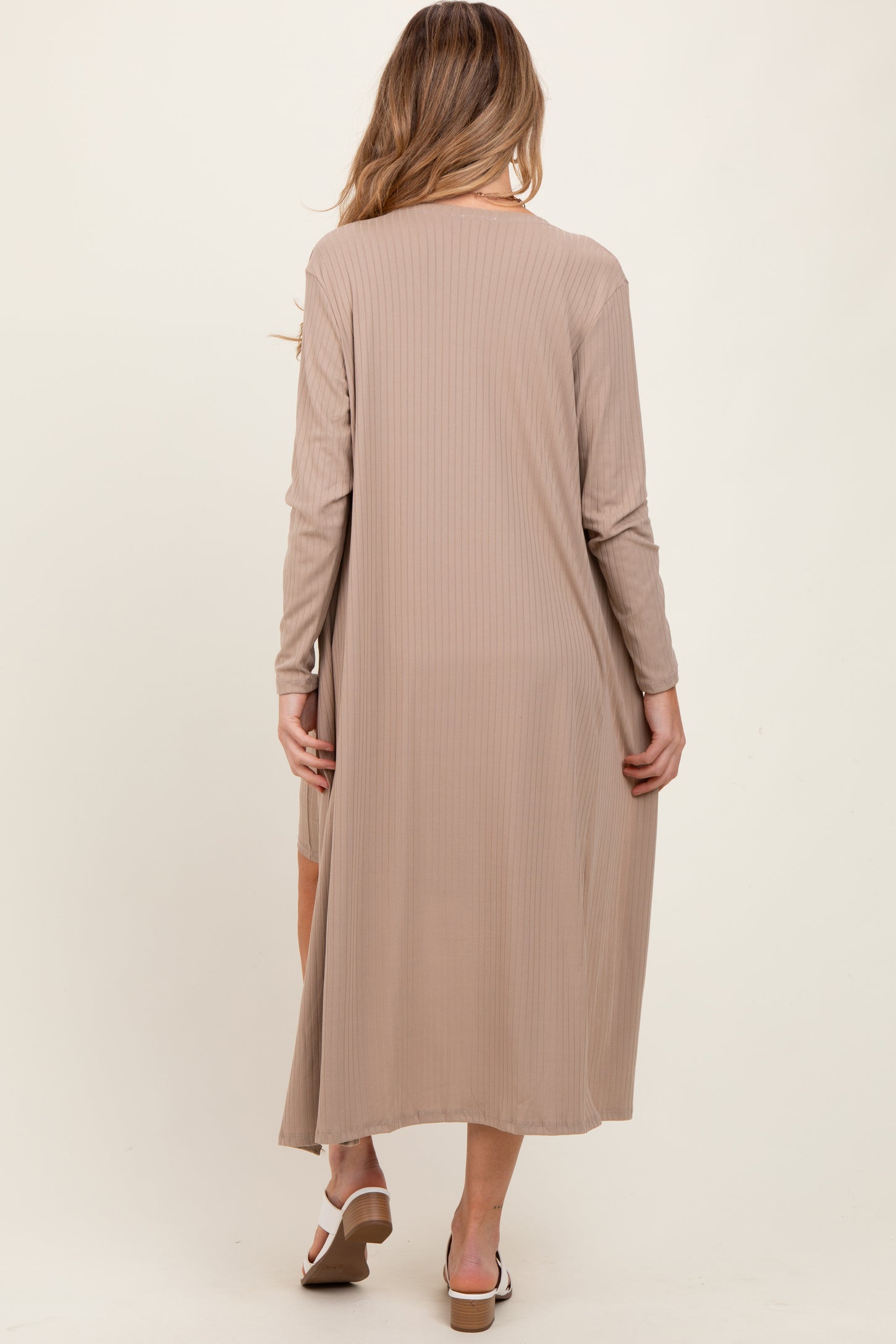 woman wearing a long beige ribbed maternity dress with long sleeves, showing the back view