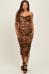 woman wearing a brown and black animal print maternity dress with a fitted silhouette and spaghetti straps