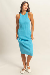 woman wearing a ribbed turquoise midi dress with a sleeveless design and a fitted silhouette