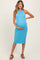 woman wearing a fitted turquoise maternity dress, showcasing her baby bump and standing in a relaxed pose