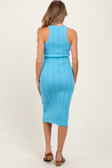 woman wearing a teal ribbed maternity midi dress, showing the back view with a fitted silhouette and side slit