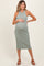 woman wearing a sage green ribbed maternity dress and holding her baby bump