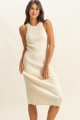 woman wearing a cream ribbed knit sleeveless midi dress with a subtle scalloped hem