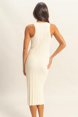 woman wearing a cream ribbed midi dress with a fitted silhouette and sleeveless design, seen from the back