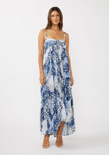 woman wearing a blue and white patterned maxi dress with adjustable straps and a tie-front detail