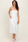 woman wearing a white strapless midi dress with a textured pattern and side pockets, standing on a neutral background