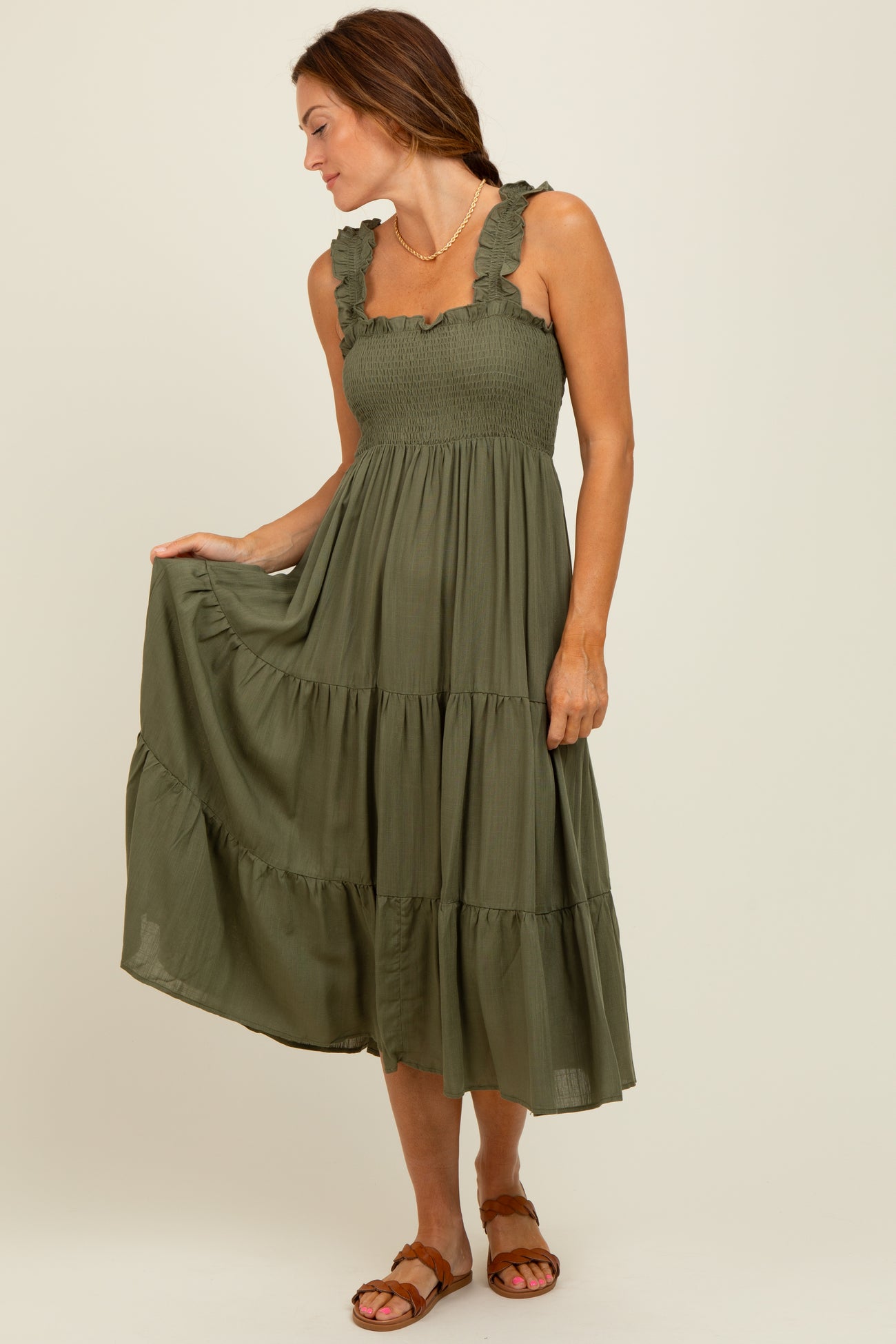 woman wearing an olive green tiered midi dress with ruffle straps and a smocked bodice