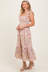 woman wearing a floral midi dress with ruffled straps and a fitted bodice, standing against a plain background