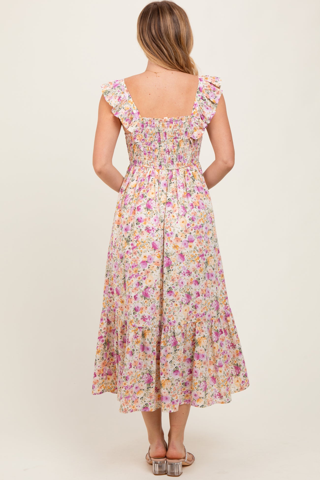woman wearing a back view of a floral midi dress with ruffle straps and a smocked bodice