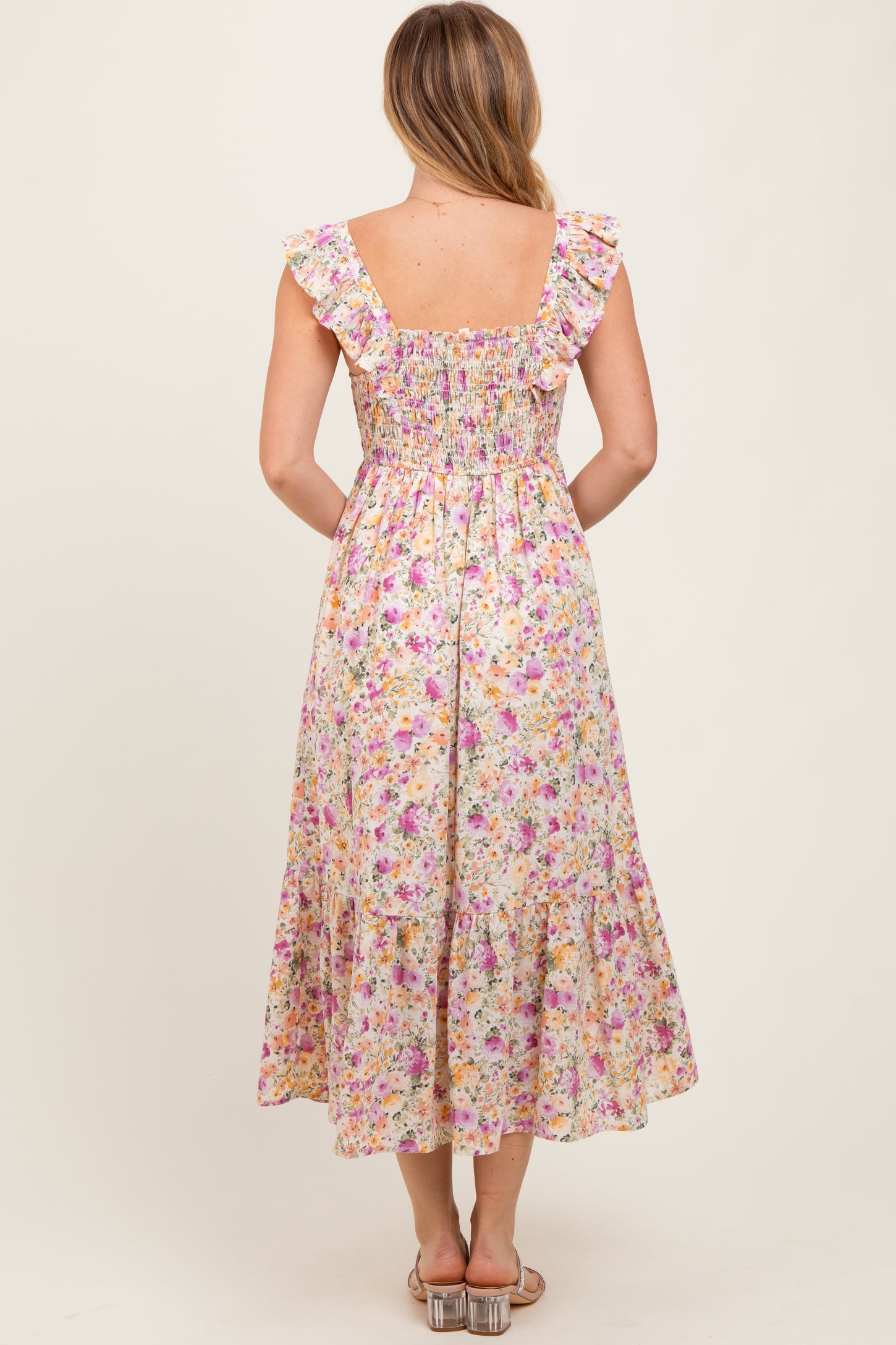woman wearing a back view of a floral midi dress with ruffle straps and a smocked bodice