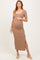 woman wearing a brown ribbed maternity dress with short sleeves and a side slit, gently holding her baby bump