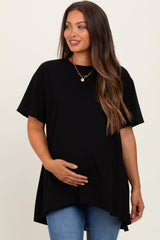 woman wearing a black short sleeve maternity top and holding her baby bump