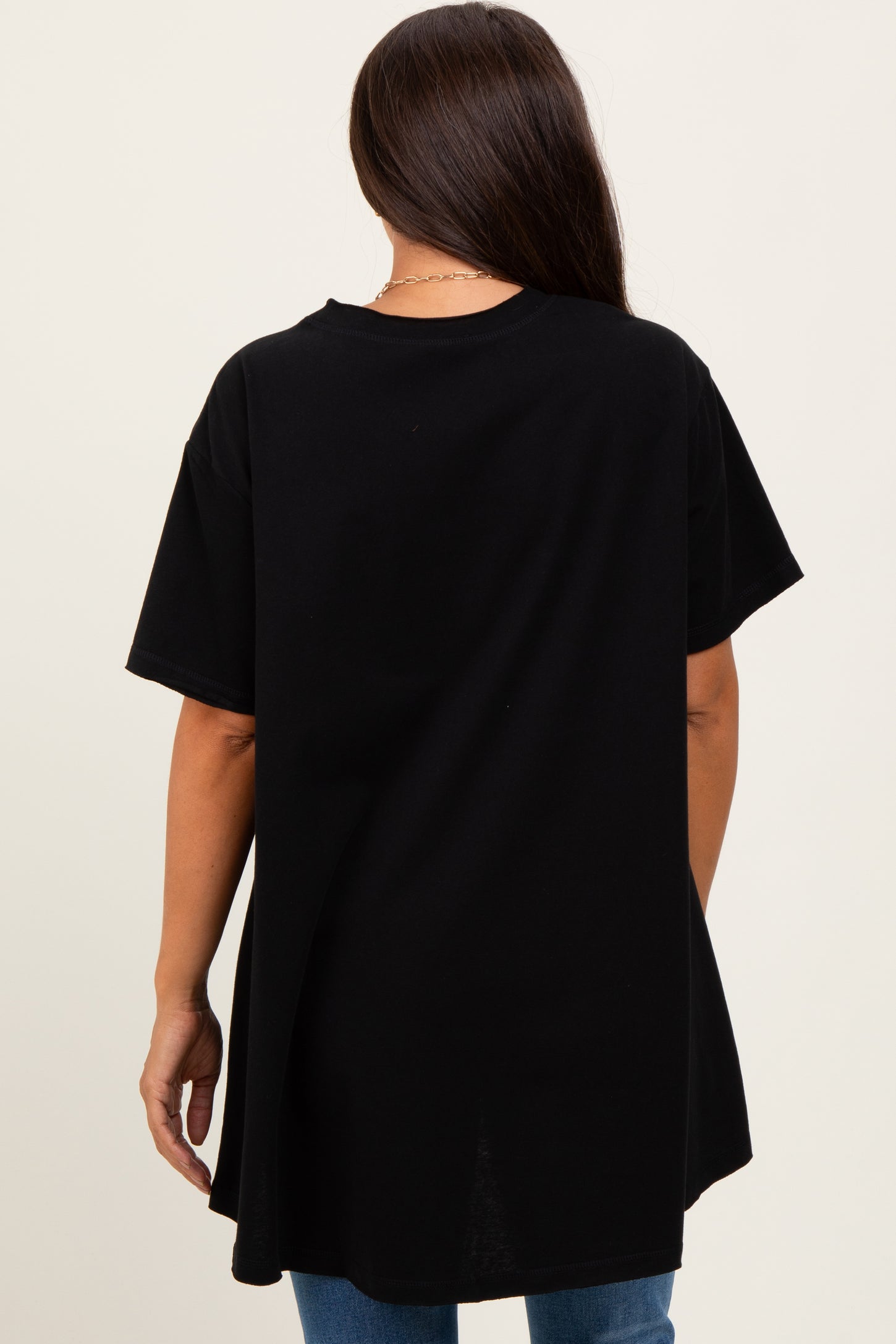 woman wearing a black oversized maternity t-shirt with short sleeves and a relaxed fit