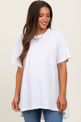 woman wearing a white oversized maternity tee with a high-low hem and smiling while standing against a neutral background