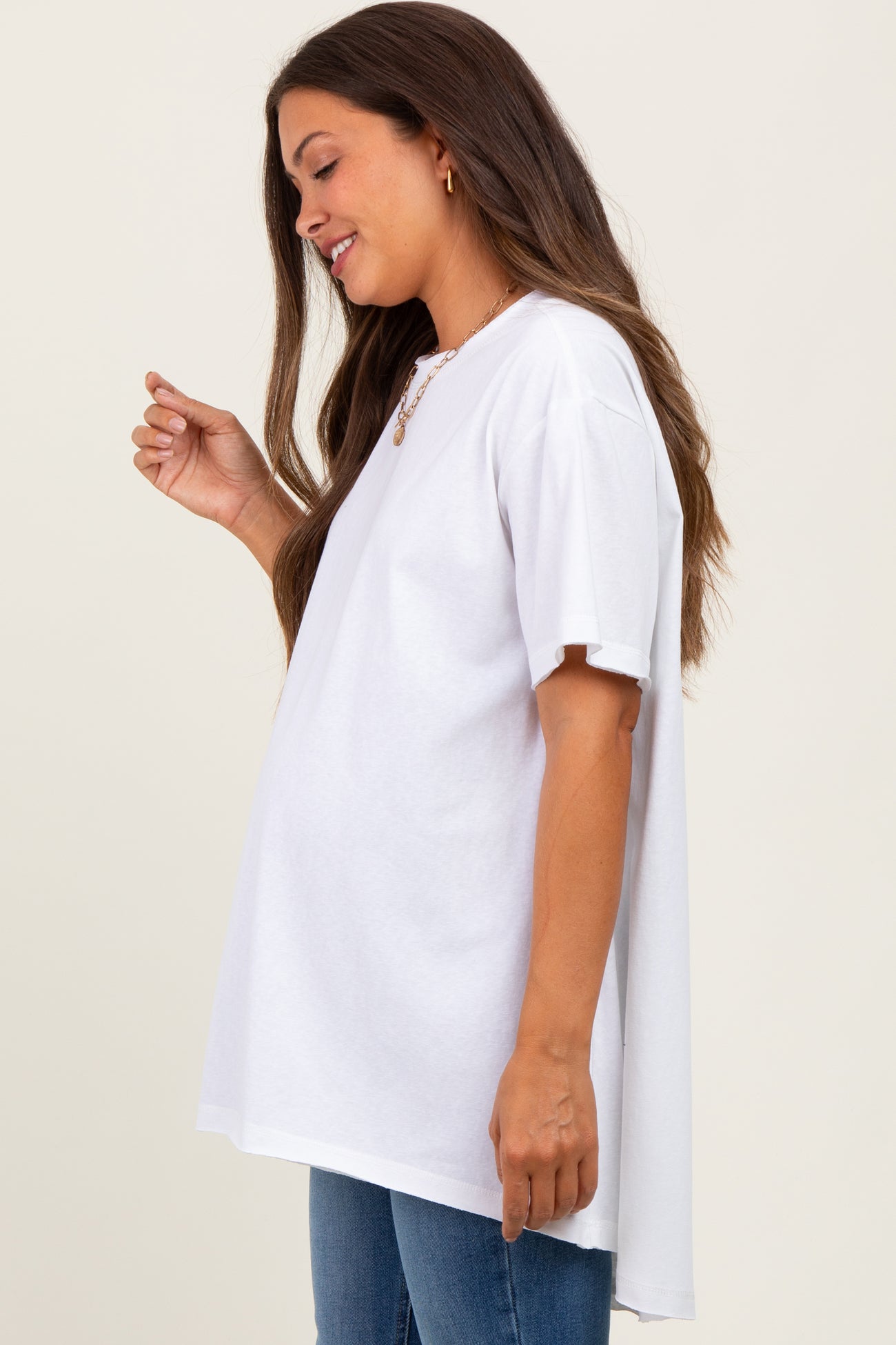 woman wearing a white oversized maternity t-shirt with a baby bump visible