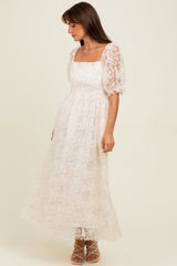 woman wearing a white floral lace long maxi dress with puff sleeves and a square neckline