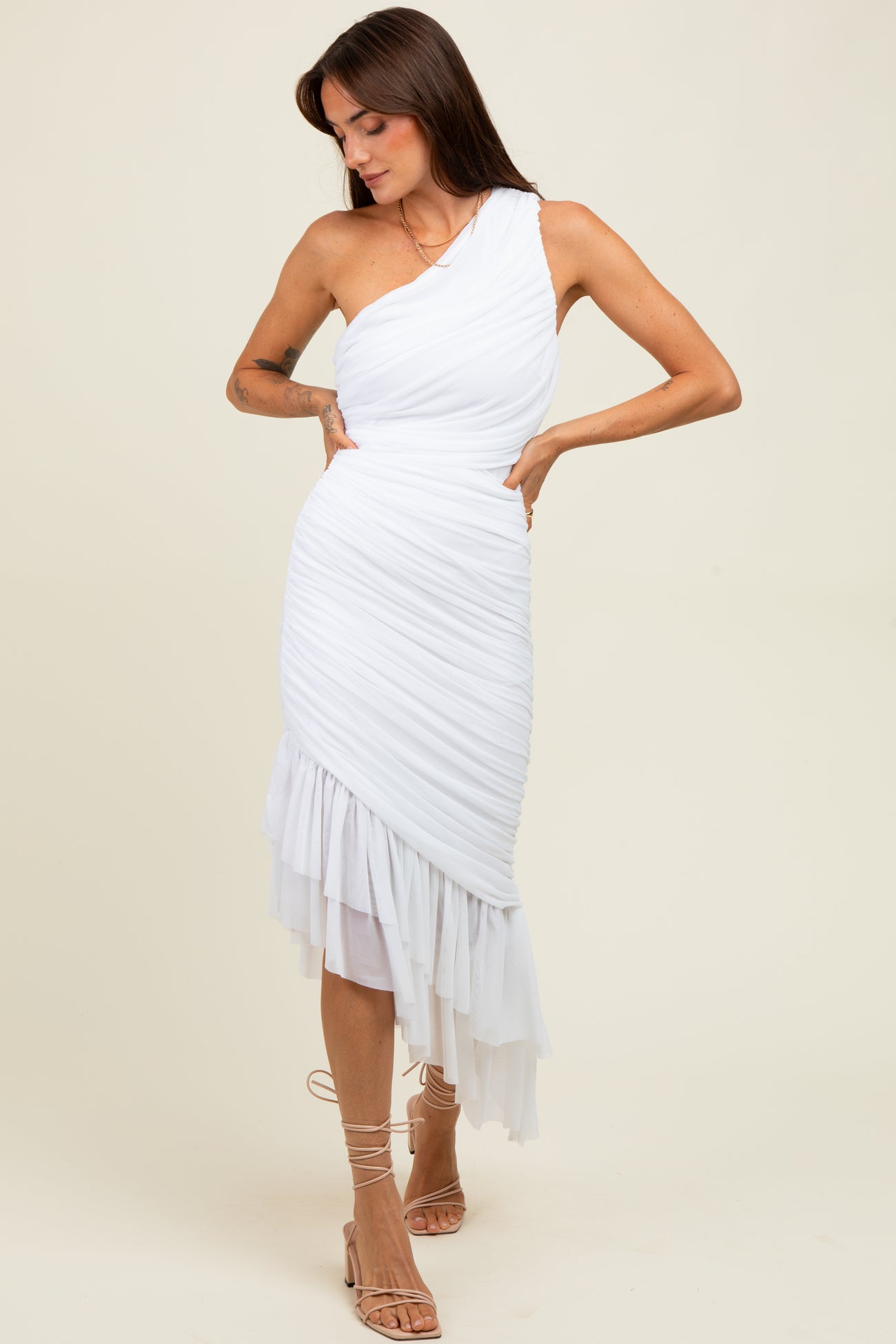 woman wearing a white one-shoulder midi dress with ruching and a flowy hemline