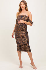woman wearing a leopard print maternity dress with off-shoulder sleeves and a visible baby bump