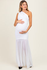 woman wearing a white one-shoulder maternity gown with ruched detailing and sheer skirt, holding her baby bump
