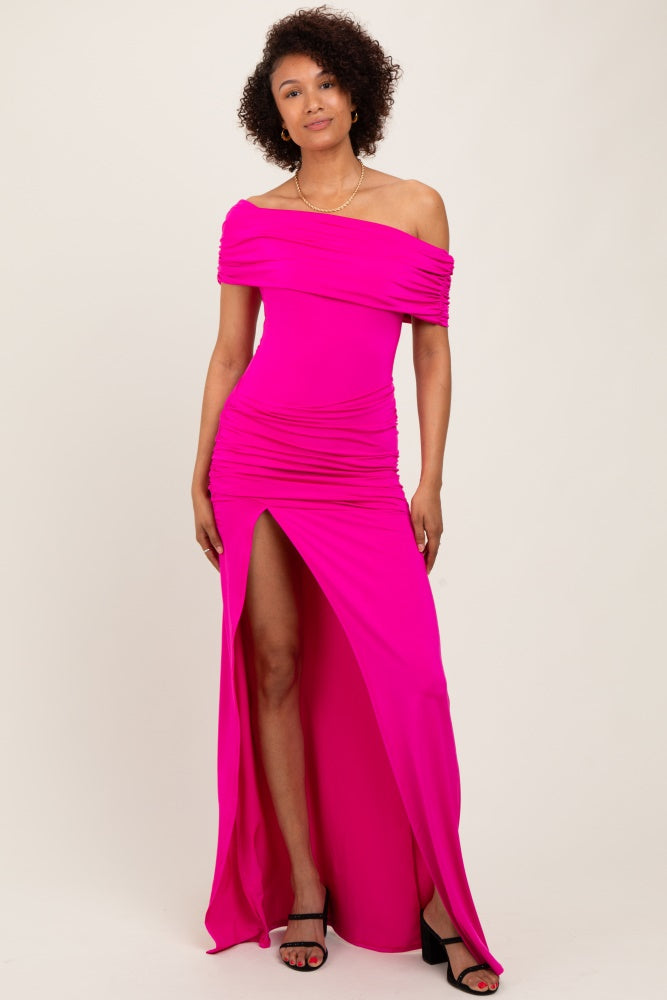 woman wearing a bright pink off-shoulder dress with ruching and a side slit, standing confidently