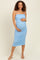 woman wearing a light blue ruched maternity dress with spaghetti straps and holding her baby bump