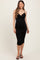 woman wearing a black maternity bodycon dress with ruching and a v-neckline, showing her baby bump