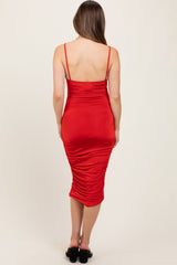 woman wearing a red fitted maternity dress with adjustable straps and gathered details at the back