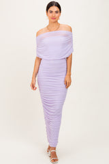 woman wearing a lavender off-the-shoulder ruched dress with a fitted silhouette and a flowing overlay