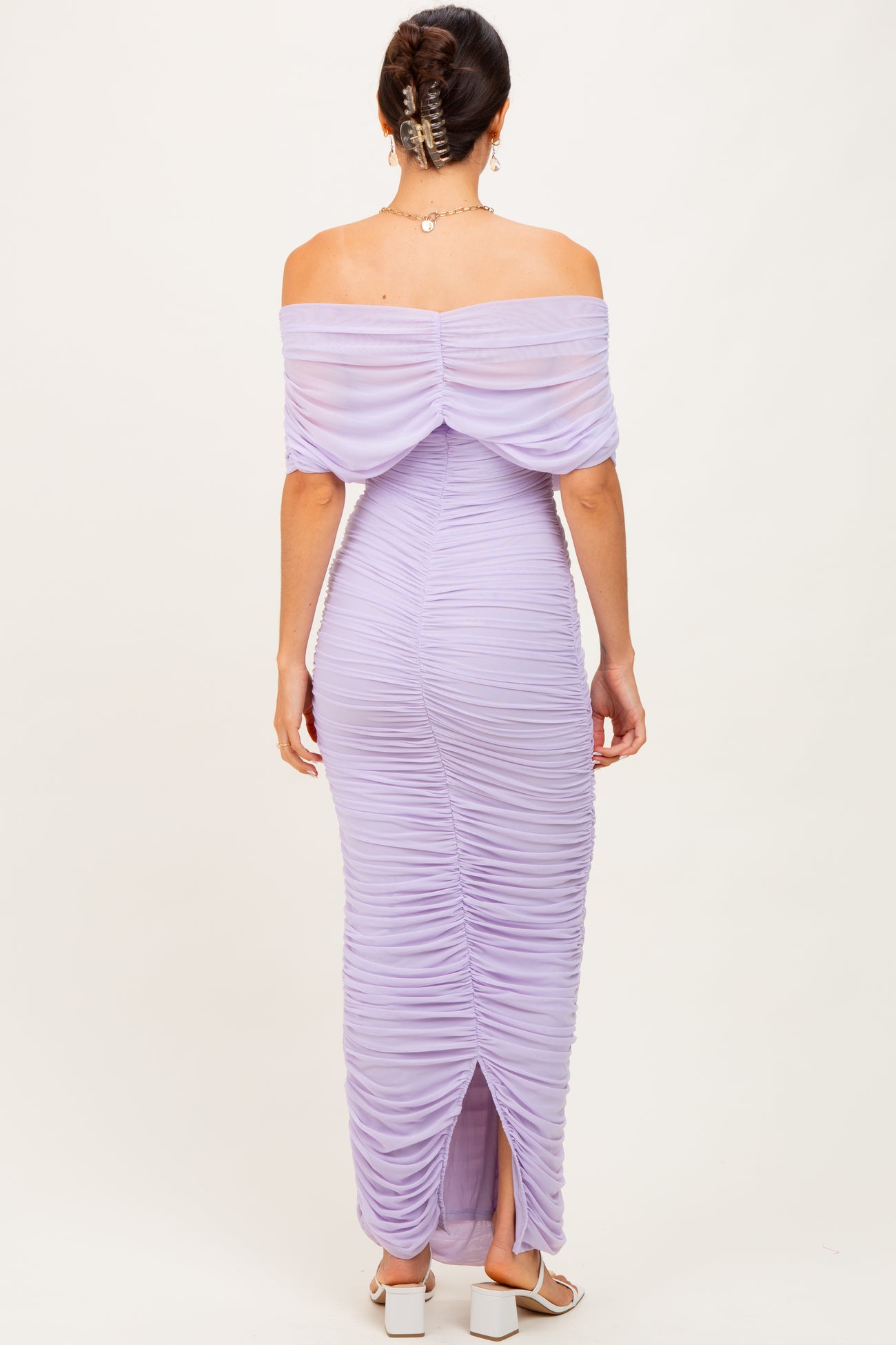 woman wearing a lilac off-the-shoulder ruched maxi dress with a thigh-high slit and back detailing