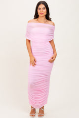 woman wearing a light pink off-the-shoulder ruched maxi dress with a fitted silhouette and side gathering