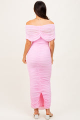 woman wearing a pink off-shoulder maxi dress with ruching details and a back slit