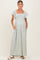 woman wearing a floral maternity maxi dress with a square neck and short flutter sleeves, hands in pockets