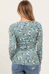 woman wearing a green floral long sleeve top with a fitted ribbed texture and back view showing the design