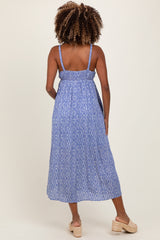 woman wearing a blue patterned maternity maxi dress with adjustable straps and a gathered back, showcasing her baby bump