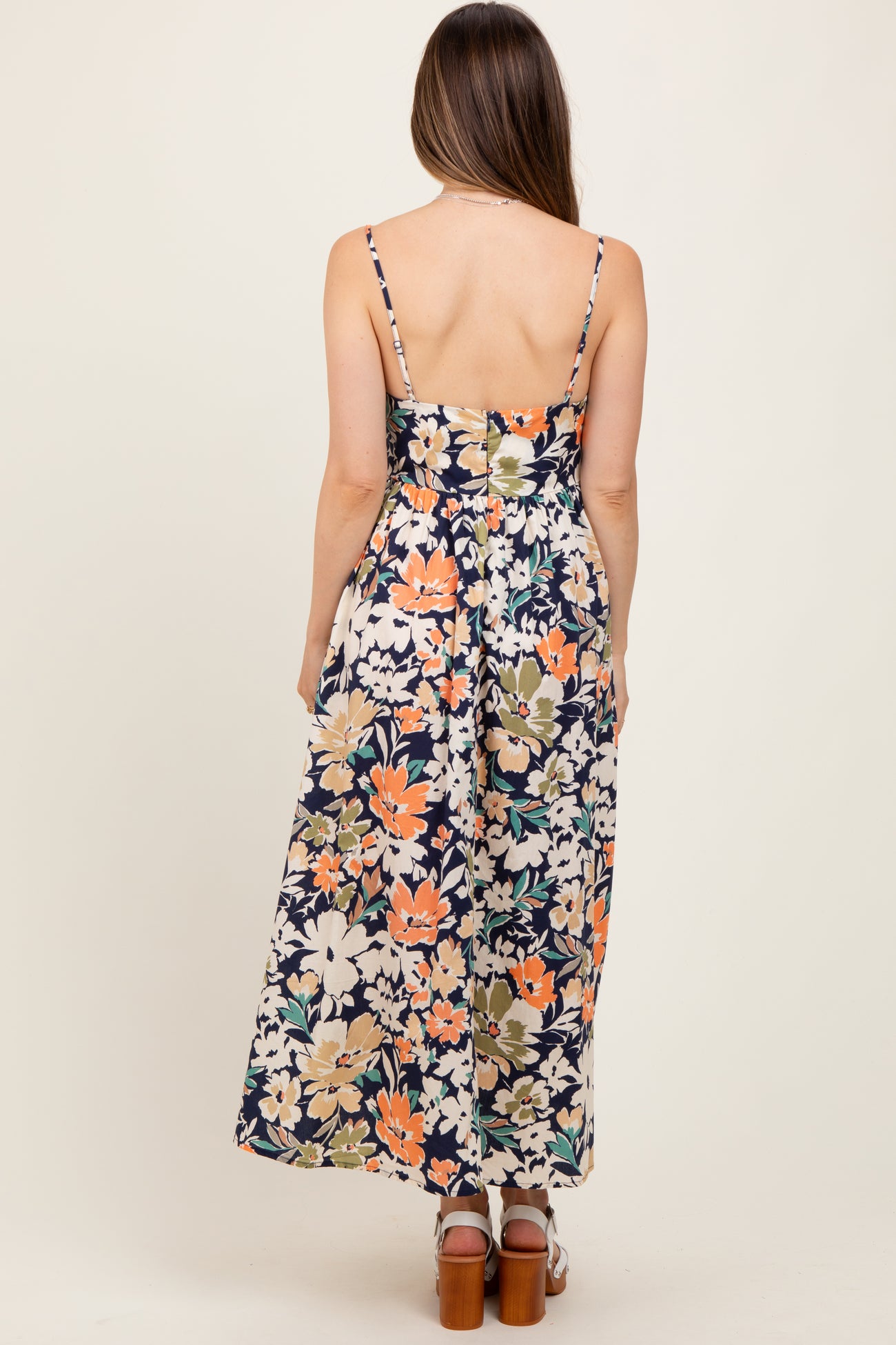 woman wearing a floral maternity maxi dress with a fitted bodice and adjustable straps, viewed from the back