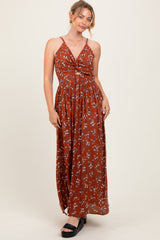 woman wearing a rust floral maxi dress with a knotted front and spaghetti straps
