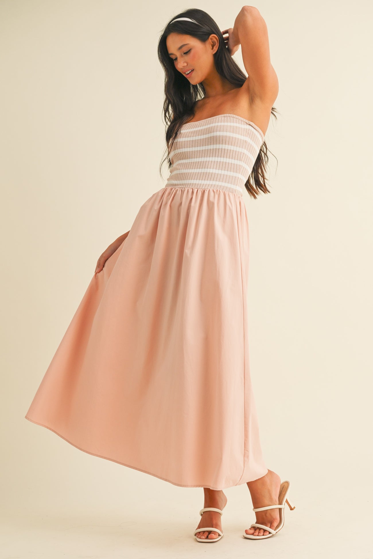 woman wearing a strapless pink maxi dress with a smocked bodice and flowy skirt