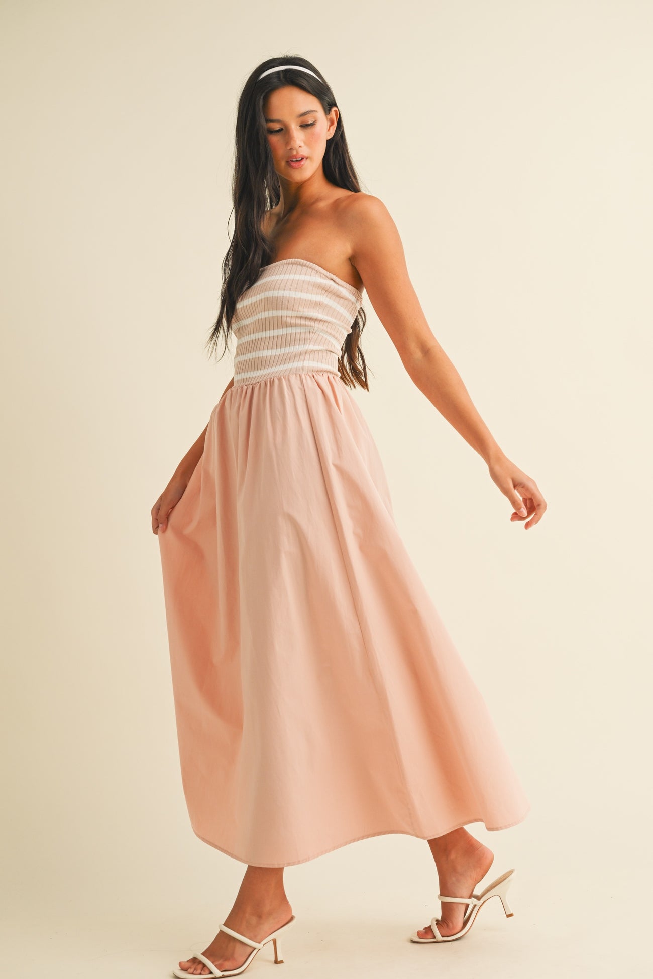 woman wearing a strapless pink maxi dress with a smocked bodice and flowy skirt