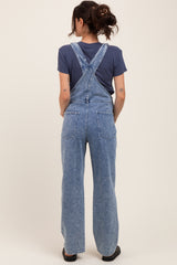 woman wearing light blue maternity denim overalls with a relaxed fit, seen from the back