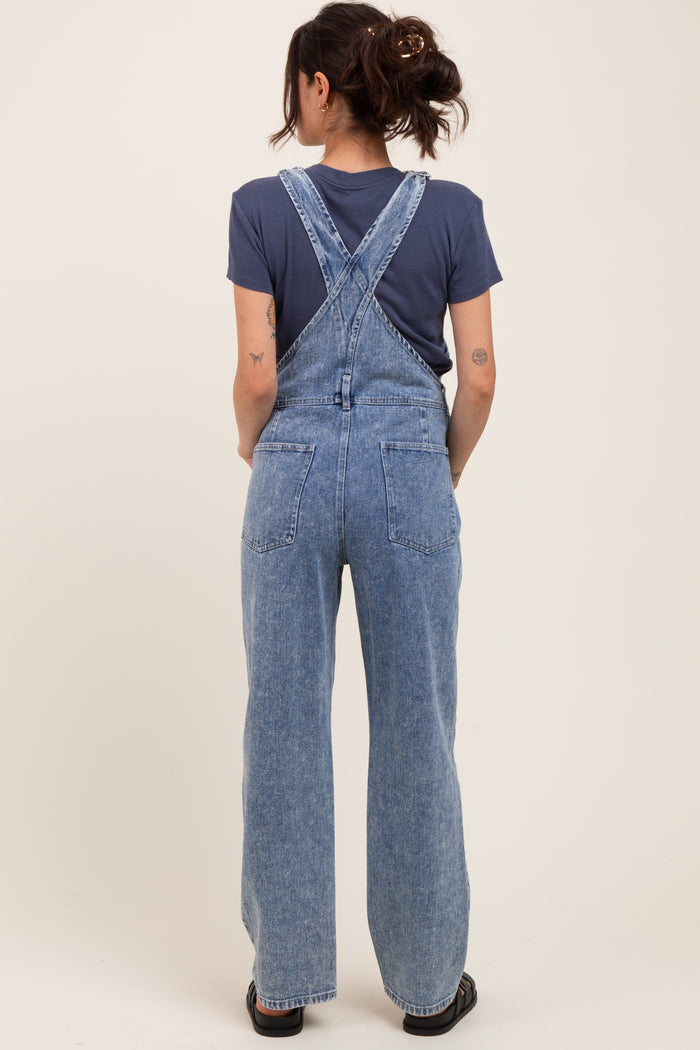 woman wearing light blue maternity denim overalls with a relaxed fit, seen from the back