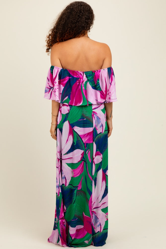 woman wearing a vibrant floral off-the-shoulder maxi dress in pink and green, showcasing the back view and flowing style