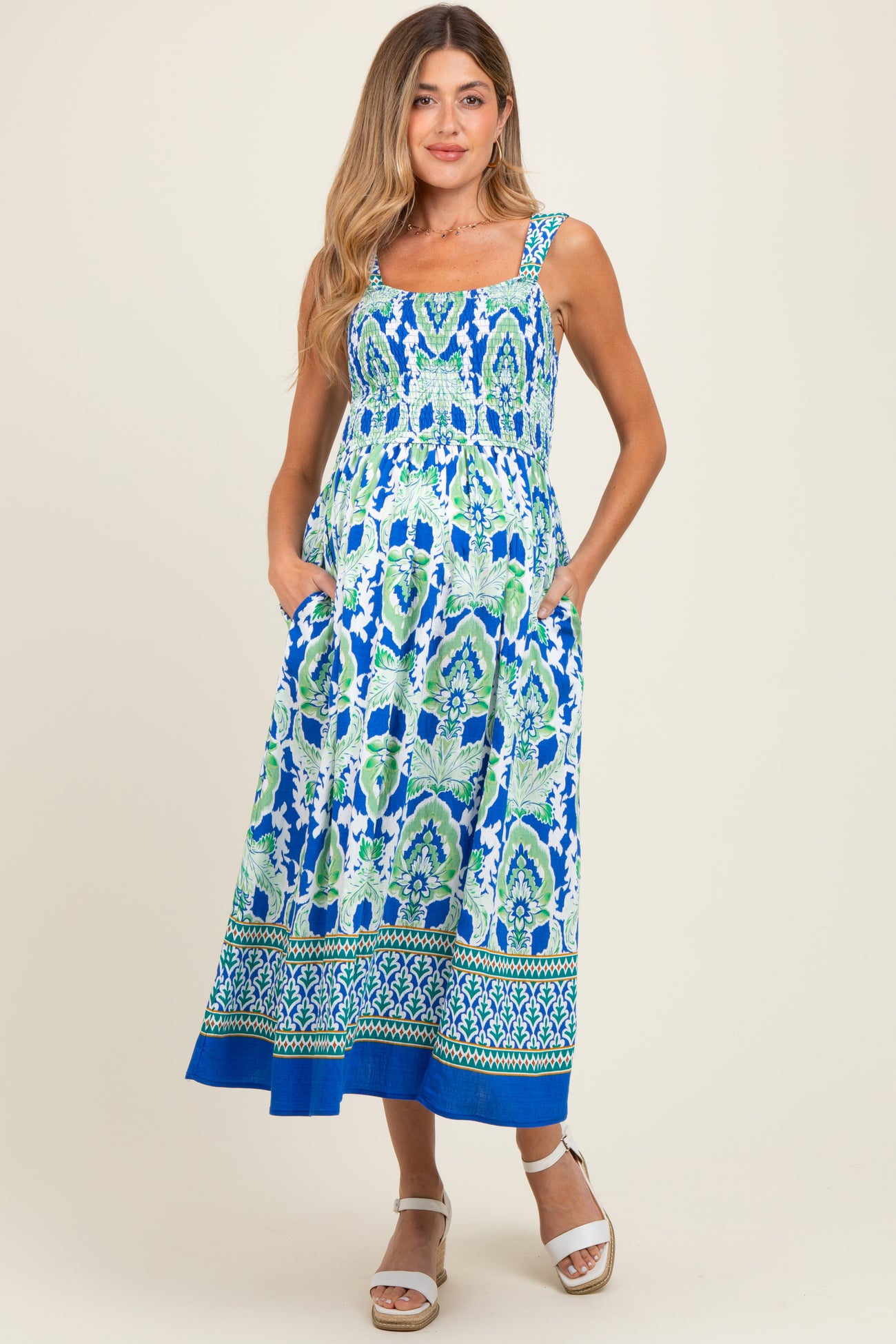 woman wearing a blue and green patterned maternity maxi dress with pockets and a square neckline