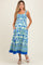 woman wearing a blue and green patterned maternity maxi dress with pockets and a square neckline